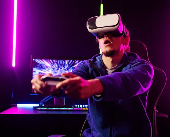 Person wearing a VR headset and holding controllers in a dark room with purple lighting.