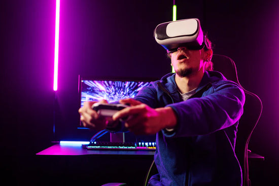 Person wearing a VR headset and holding controllers in a dark room with purple lighting.